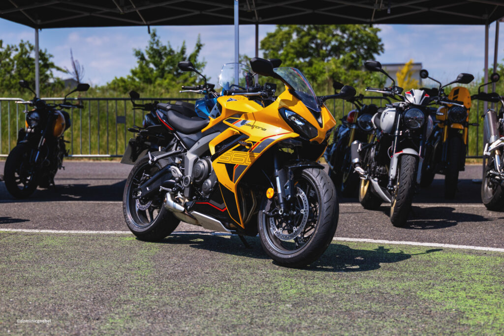 Motorrad Testtage 2026 Teesdorf c Dominic Goebel-4 - I love my moped Bright yellow sport motorcycle in the foreground, with other bikes parked under a canopy in the background.