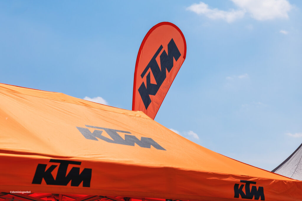 Motorrad Testtage 2026 Teesdorf c Dominic Goebel-5 - I love my moped Orange KTM promotional tent set up outdoors with a clear blue sky in the background