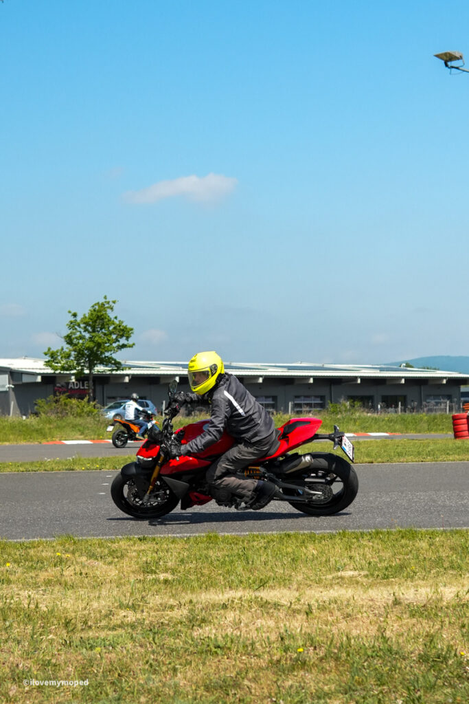 arge2rad-motorradtesttage2026-teesdorf-43 - I love my moped Motorcyclist wearing a bright yellow helmet riding a red sport bike on a track surface.