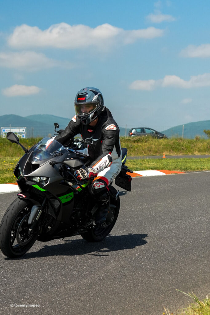 arge2rad-motorradtesttage2026-teesdorf-46 - I love my moped Motorcyclist wearing full protective gear on a dark sport bike with neon green accents on a track under a blue sky.