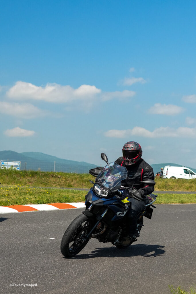 arge2rad-motorradtesttage2026-teesdorf-50 - I love my moped Motorcyclist wearing a full-face helmet and protective gear riding a blue adventure motorcycle on a sunny day.